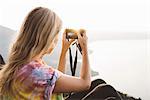 Young woman photographing at Lake Atitlan on digital camera, Guatemala