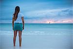 Rear view of young woman looking out to sea at sunset, Boracay Island, Visayas, Philippines