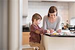 Mother and son drawing together in kitchen