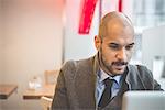 Businessman sitting in cafe using laptop