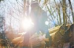 Man in trapper hat chopping wood in countryside