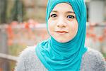 Close up portrait of young woman wearing turquoise hijab