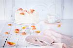 Still life of cream cake on cake stand garnished with rose petals