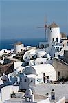 View of white washed hillside town and windmill, Oia, Santorini, Cyclades, Greece