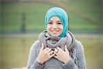 Portrait of young woman in park wearing turquoise hijab