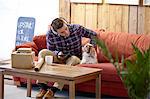 Mid adult man petting dog in picture framers showroom