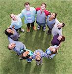 Team forming connected circle basking in sunny field