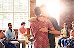 Men hugging at group therapy session