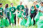 Smiling environmentalist volunteers picking up trash