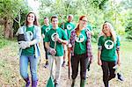 Smiling environmentalist volunteers planting new tree