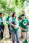 Smiling environmentalist volunteers planting new tree