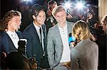 Celebrities being interviewed and photographed by paparazzi at event