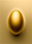 Overhead view of golden egg on gold background still life