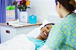 Smiling patient in hospital bed smiling at nurse