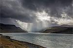 Sunbeams over cliffs and fjord, West Fjords, Iceland