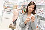 Customer reading label on box in pharmacy