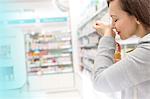 Woman trying on perfume in pharmacy