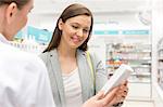 Pharmacist recommending product to customer in pharmacy