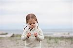 Curious girl examining pebbles on beach