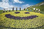 Large family group on hill with happy face floral display