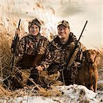 father and son duck hunting with their dog