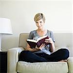 woman reading a book on the couch