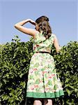 woman looking over a hedge