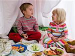 brother and sister in a makeshift fort eating lunch