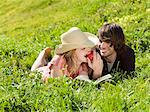 Couple eating apple and lying on grass