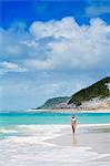 South America, Brazil, Bahia, Trancoso, An attractive young woman in a bikini walking on Espelho beach (Mirror Beach) (MR)