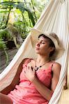 South America, Brazil, Bahia, Trancoso, a young woman relaxing in a hammock in the Mata Nativa Pousada, (MR) (PR)