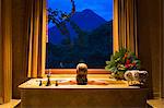 Costa Rica, Alajuela, La Fortuna. A lady looks out at the Arenal Volcano from a suite in the The Springs Resort and Spa. (MR).