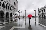 Italy, Veneto, Venice. Woman with red umbrella in front of Doges palace with acqua alta (MR)