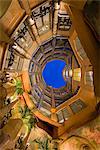 Bottom view of the inner courtyard of Casa Mila or La Pedrera at dusk, Barcelona, Catalonia, Spain