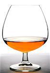 Glass with cognac on white background and wood base. Front view with copyspace. Close up shot. High resolution