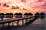 Maldives  sunset with water villas silhouette