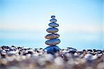 Stones balance on beach, sunrise shot. stack of zen stones on beach on blue sky background