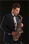 Photo of a teenager and his saxophone. Professional musician preparing for concert.