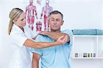 Doctor stretching a man arm in medical office