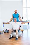 Trainer examining his patient back in fitness studio