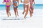 Happy friends running out of water together at the beach