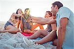 Happy hipsters drinking beer at the beach