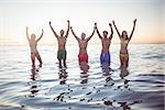 Happy friends having fun in the water at the beach