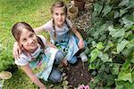 Two girls gardening, planting flowers together