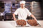 Confectioner presenting baking trays with pastries