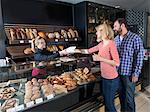 Female shop assistant in a bakery serving customers