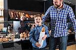 Father and son buying bread in a bakery