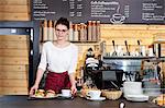 Waitress in coffee shop serving sandwiches on a tray