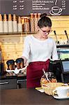 Waitress in a coffee shop serving coffee to go