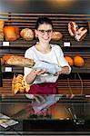 Shop assistant in bakery selling organic bread